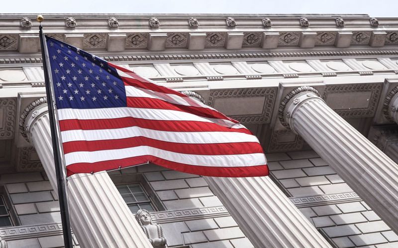 An american flag is waving in front of a building