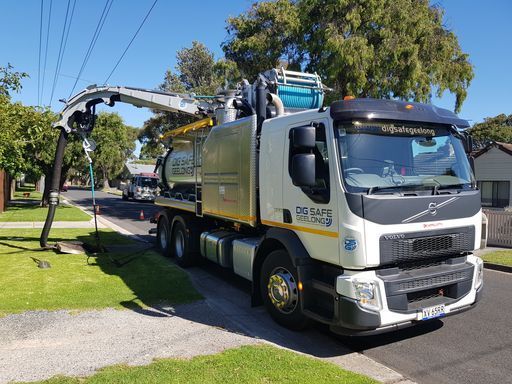 A vacuum truck parked on the curb.