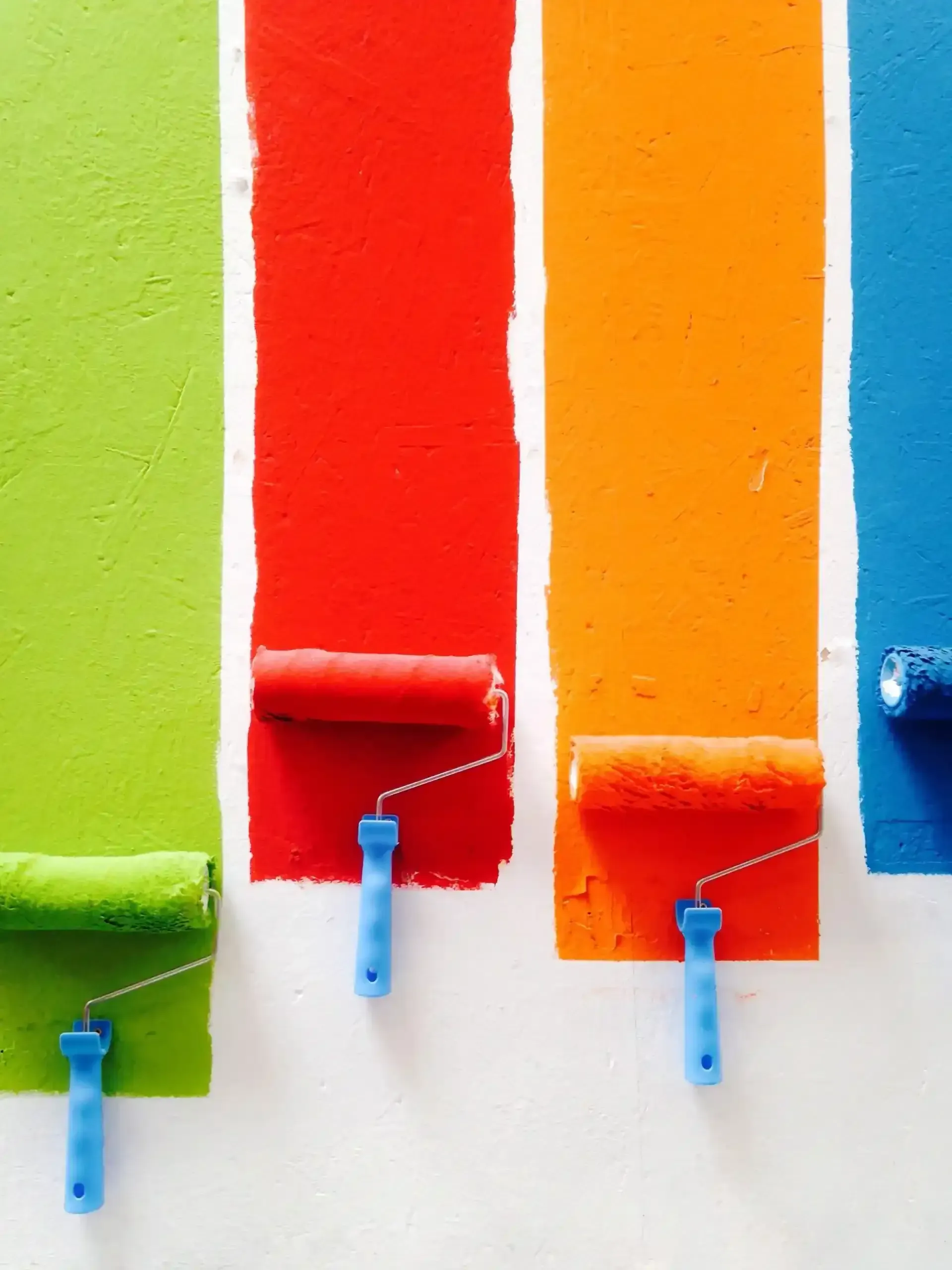 Paint Rollers Applying Green, Red, Orange, and Blue Stripes — Jamie Frankham Painting in Goonellabah, NSW