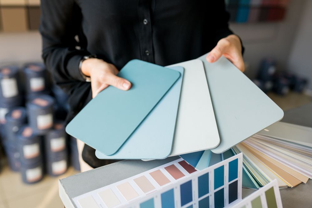 Woman Holding Blue Paint Color Swatches, Comparing Shades — Jamie Frankham Painting in Casino, NSW