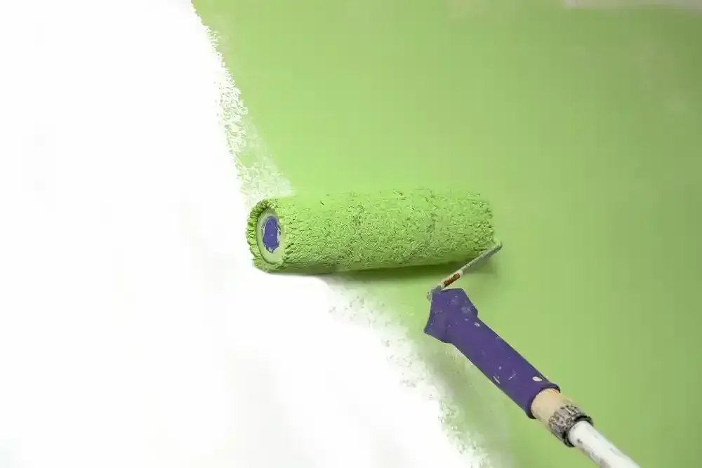 Green Paint Roller Applying Paint to a White Wall — Jamie Frankham Painting in Goonellabah, NSW