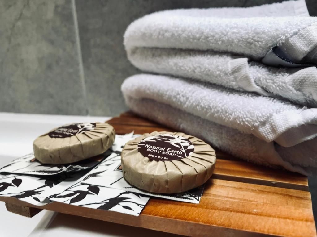 A stack of towels and soap on a wooden tray