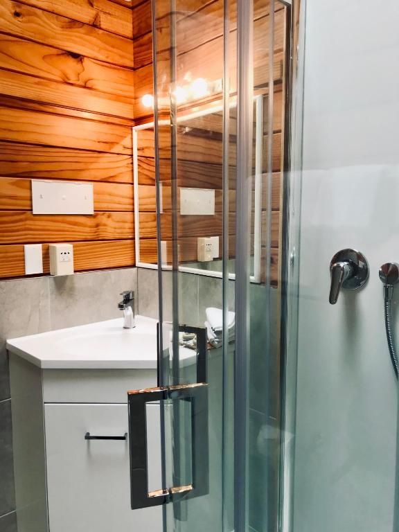 A bathroom with a sink and a shower stall