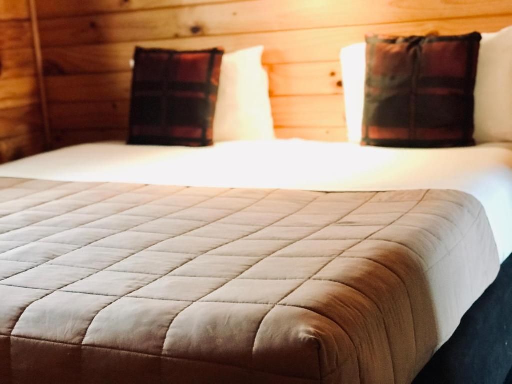A hotel room with a bed , chair , table and nightstand.