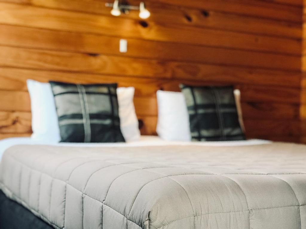 A bed with a quilt and pillows in a hotel room.
