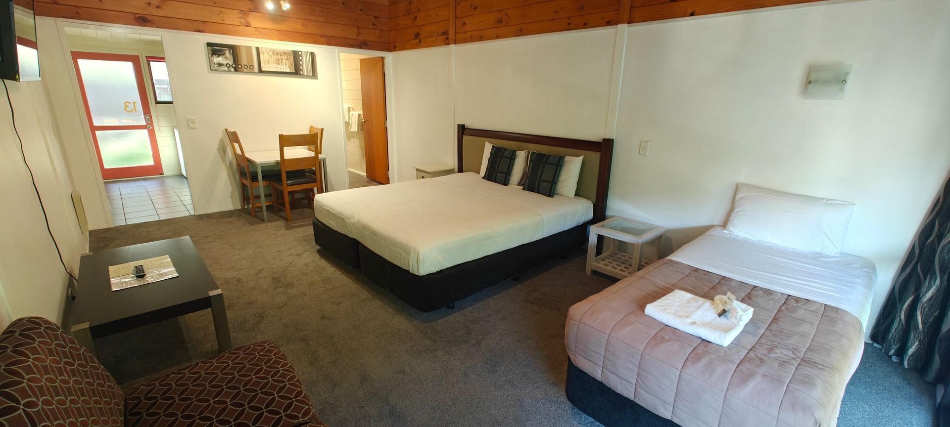 A hotel room with two beds , a table and chairs.