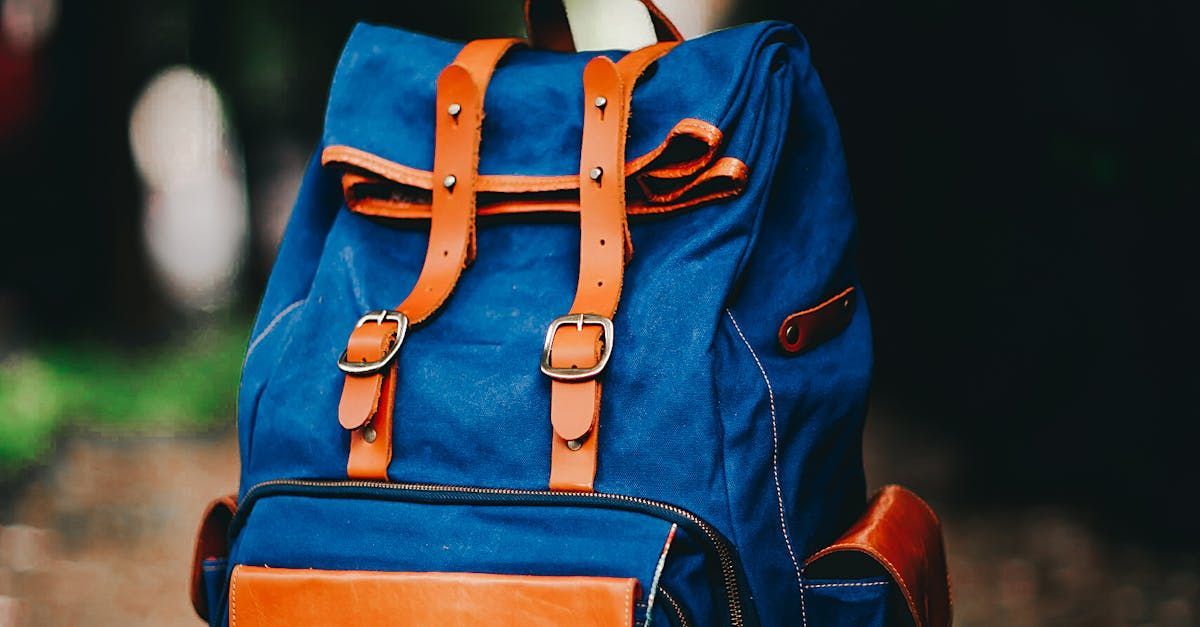 A blue backpack with brown straps is sitting on the ground.