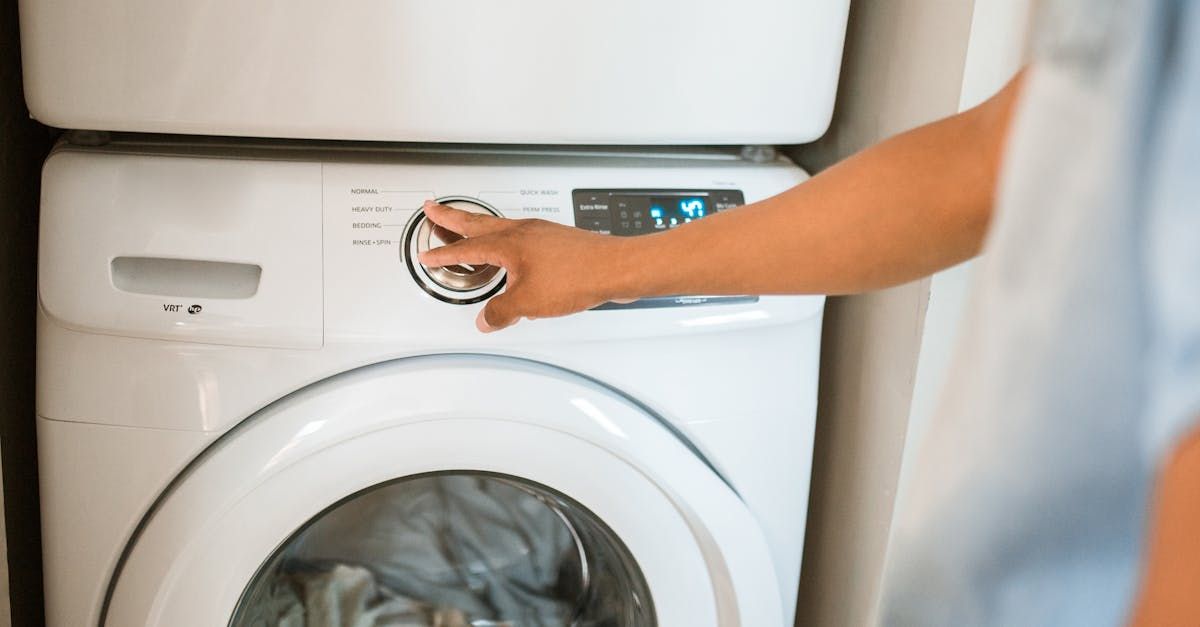 A person is pressing a button on a washing machine.