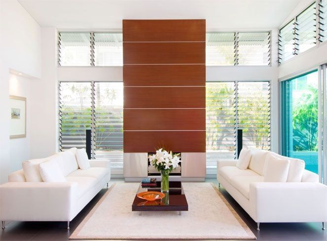 A living room with two white couches and a fireplace
