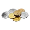 Collection of gold and silver coins, including maple leaf and eagle designs, scattered on a white surface.