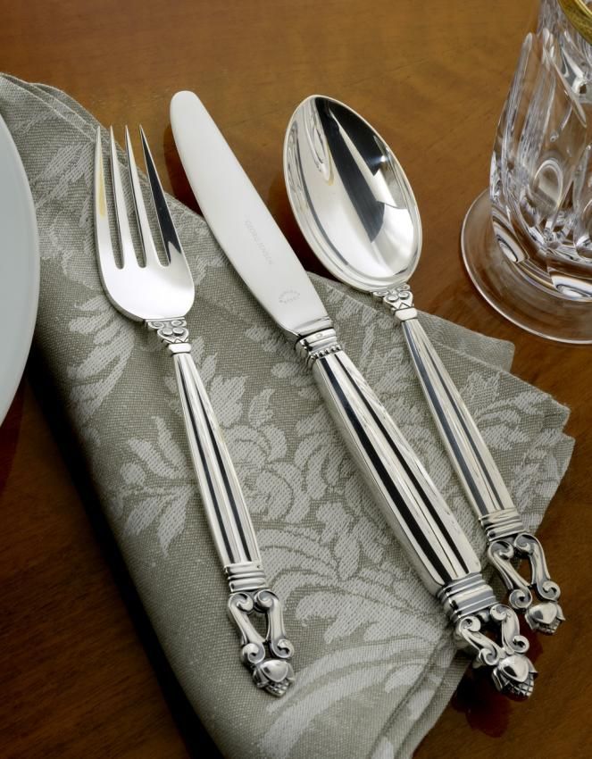 Silverware set on a gray patterned napkin: fork, knife, and spoon.