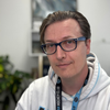 Man wearing glasses, white hoodie with