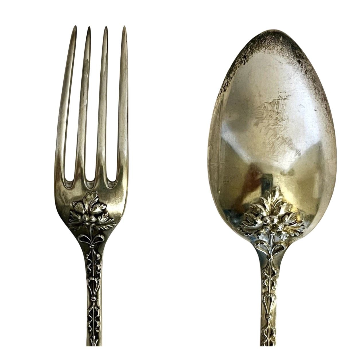 Fork and spoon with floral and decorative designs, possibly antique silverware.