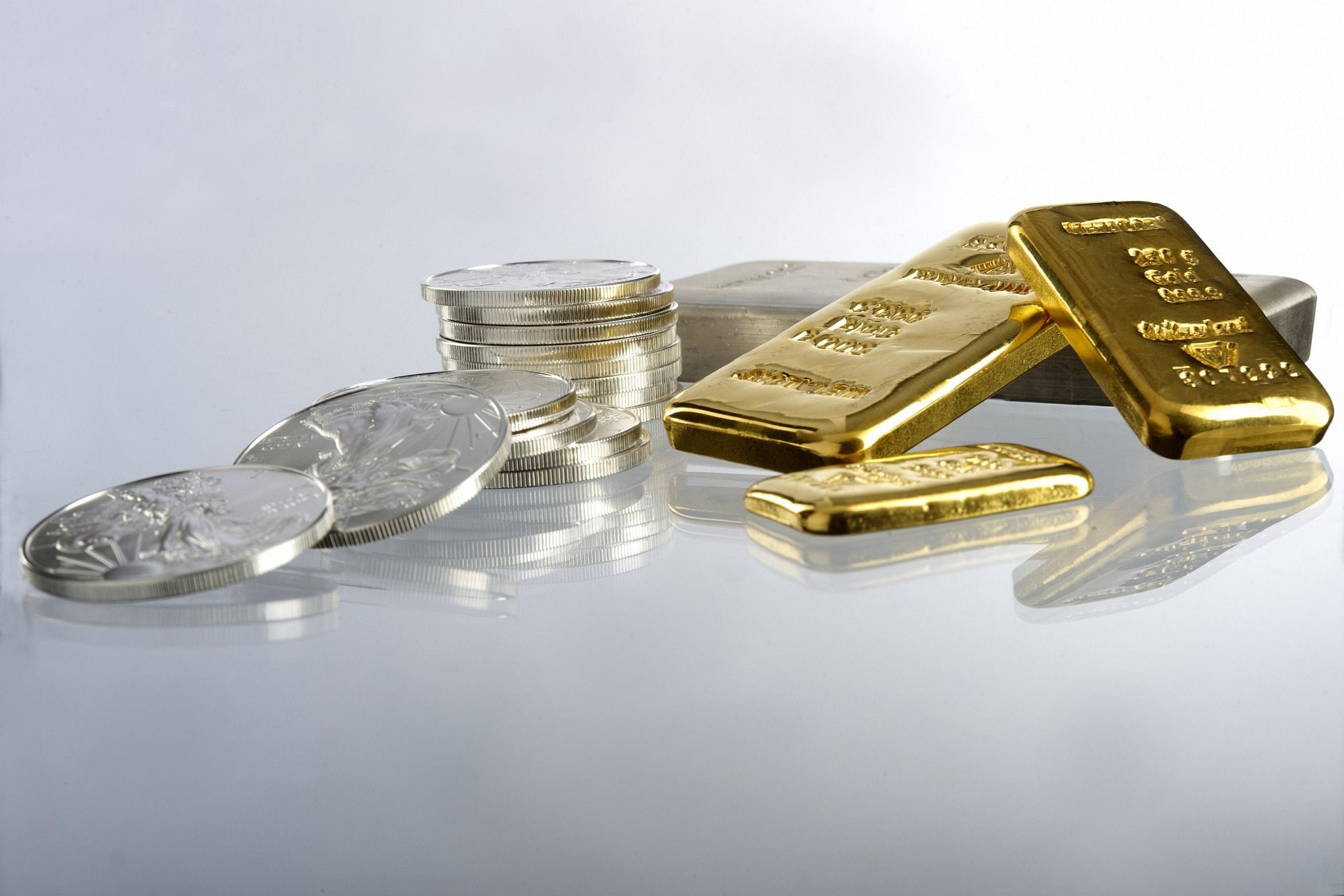 Stacks of silver coins and gold bars.