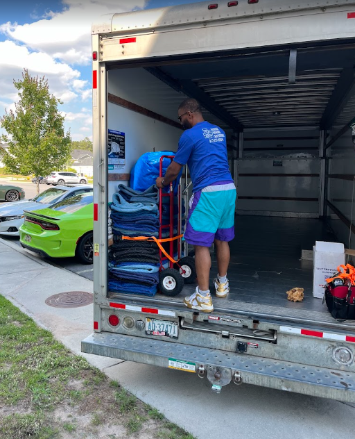 Man loading moving truck with a hand truck.