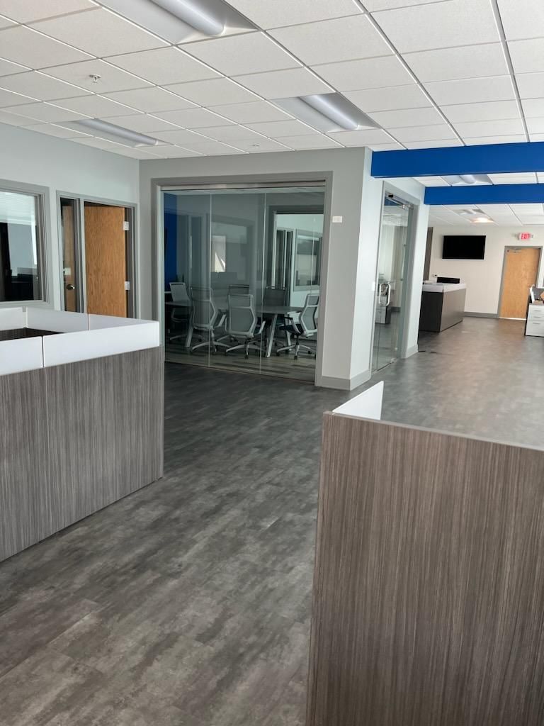 Modern office lobby with gray counters, glass walls, and wood-look flooring