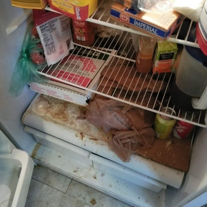 Messy freezer drawer with scattered food packages, meat, and spilled ice or frost inside.