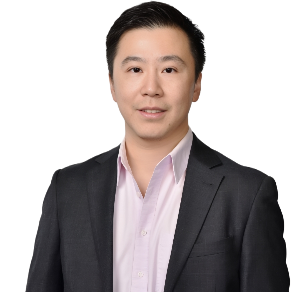 Man in a dark suit jacket and pink shirt smiles at the camera against a white background.