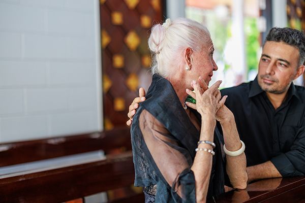 A senior woman and her son participate in a funeral ceremony at a Catholic church A senior woman and her son participate in a funeral ceremony at a Catholic church