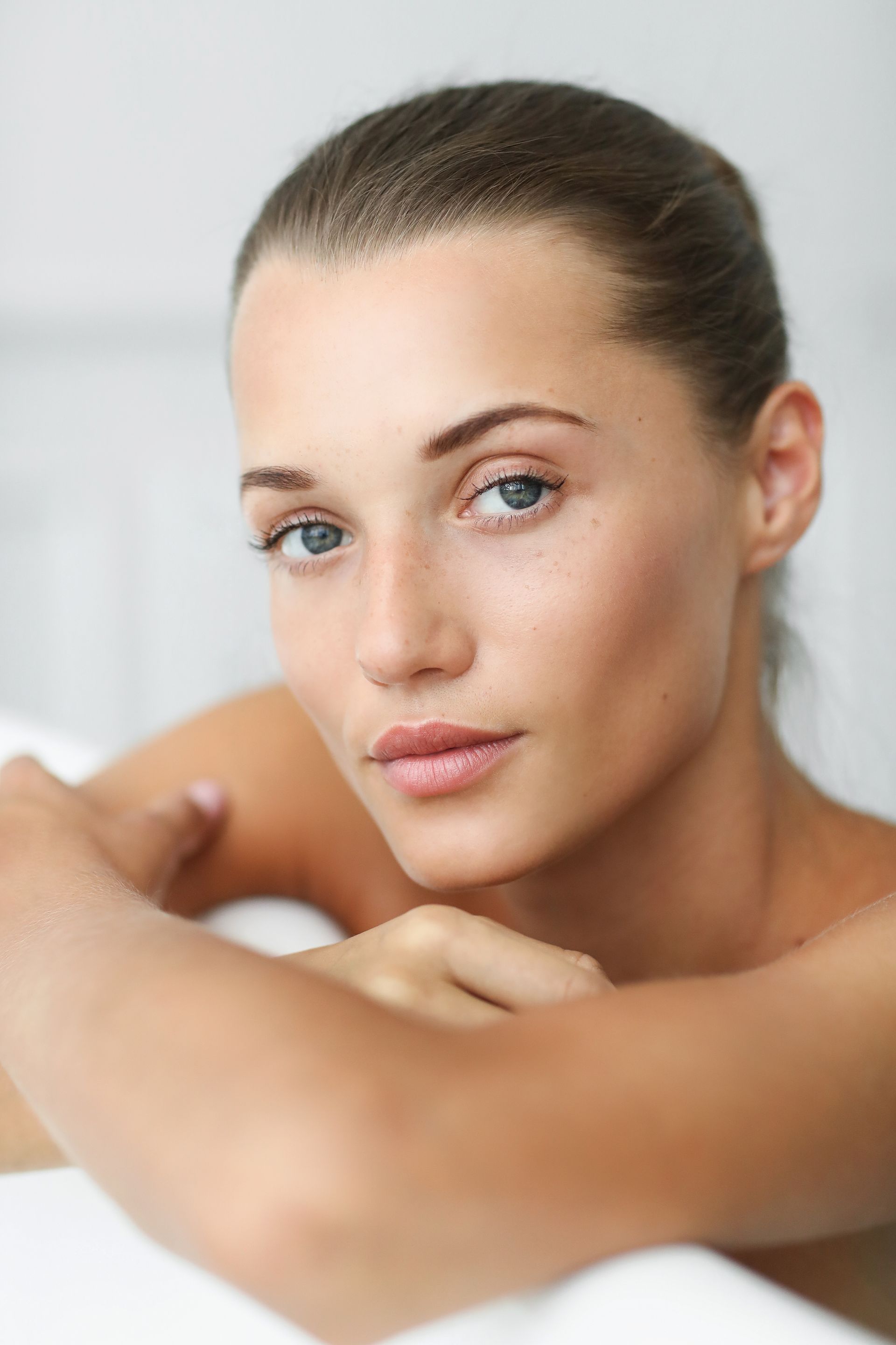 a close up of a woman 's face with her hand on her shoulder