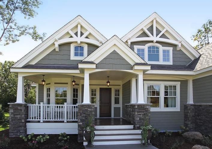 Front view of a gray Craftsman-style house with white trim, a covered porch, and stone columns