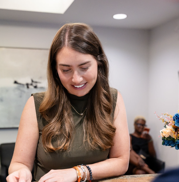Woman smiling and looking down at her wrist in a bright office