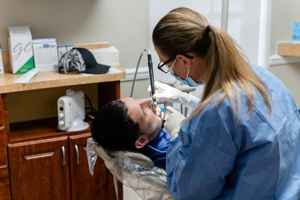 Dentist examining a patient in a clinic, leaning over the dental chair