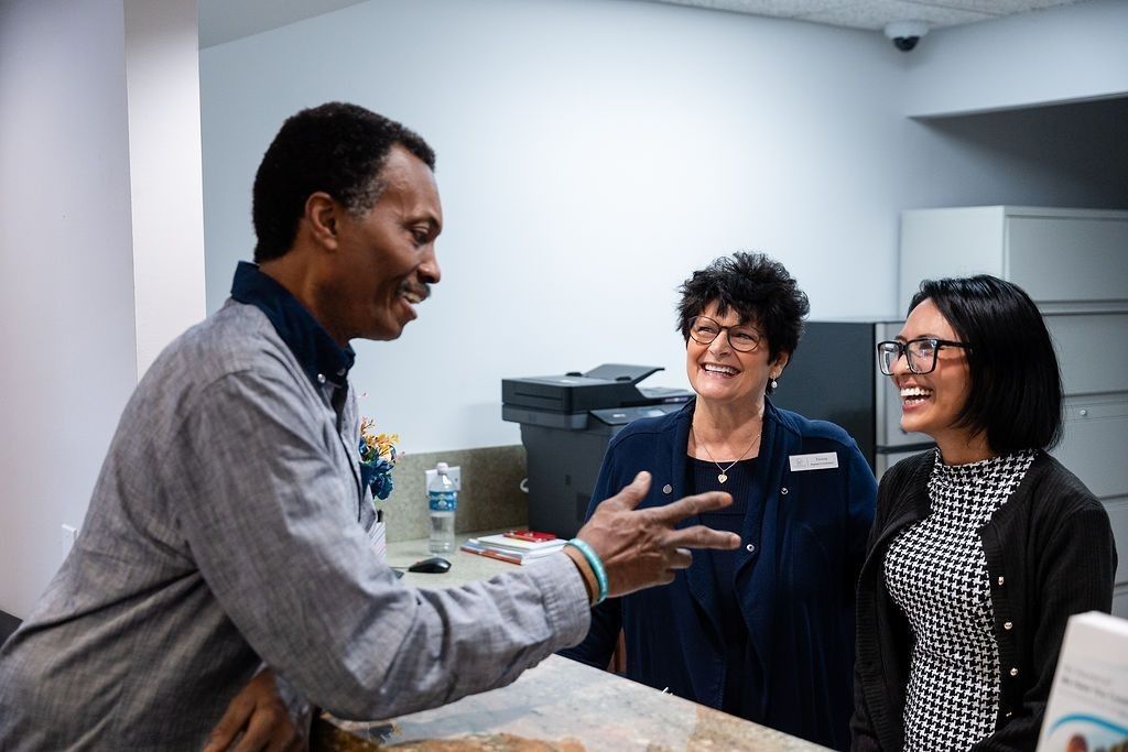 Patient laughing with the front desk team at My Pompano Dentist