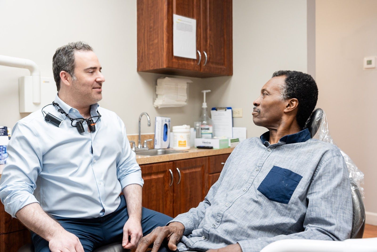Dr. Andrew Browne sitting with a patient to talk through tooth replacement