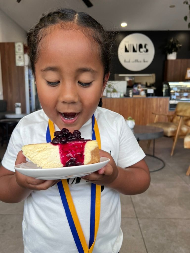 A young boy looking hungrily at a piece of cake from The Nines Cafe Maroochydore