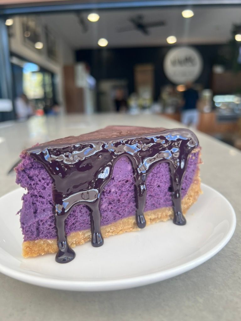 Close up of a baked purple cake with sauce drizzled over the top