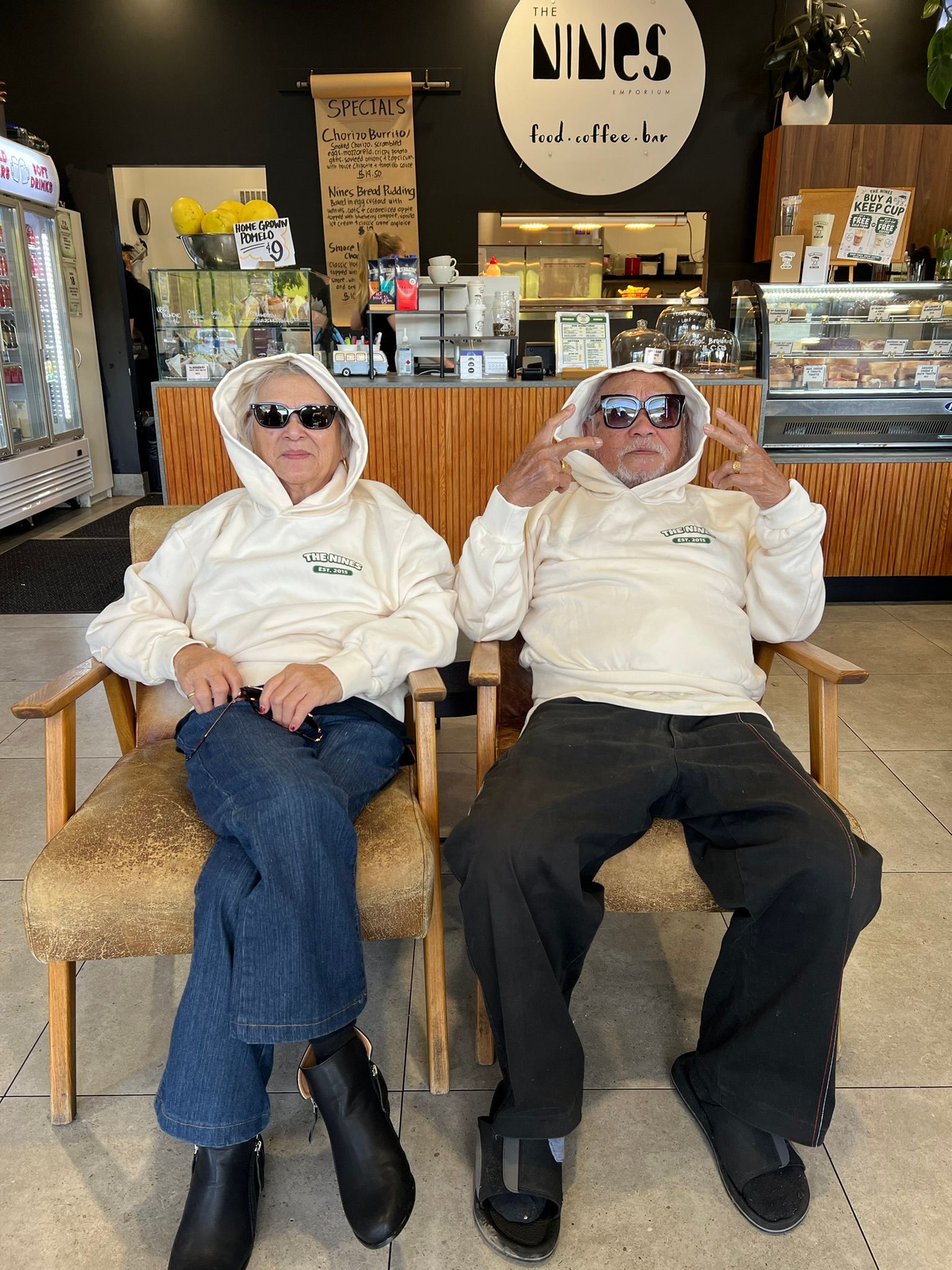 Two elderly people sitting in the cafe chairs relaxed