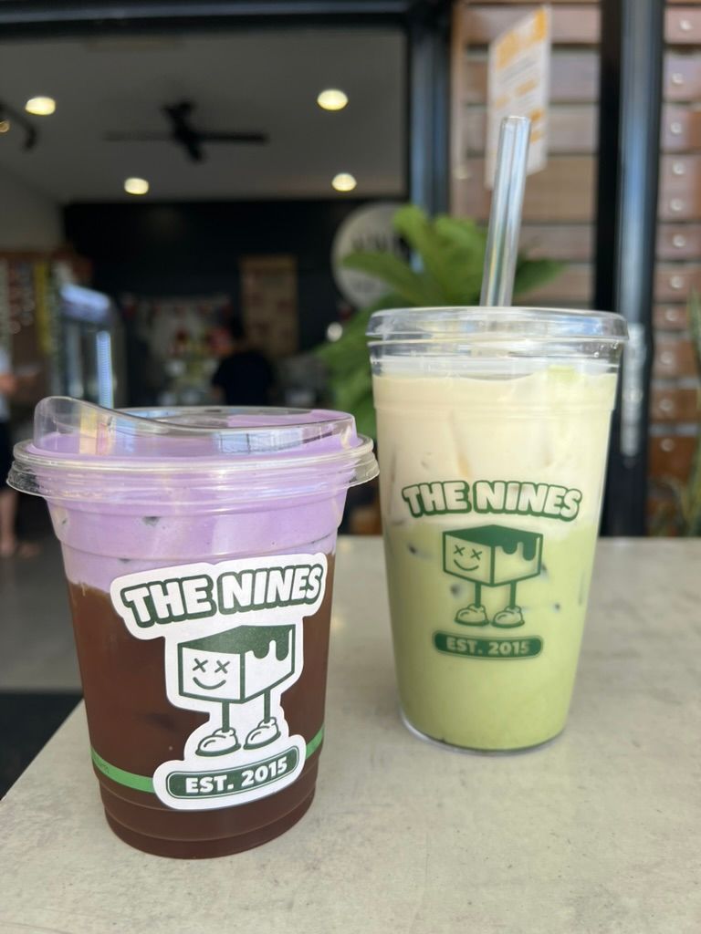 Close-up shot of two cold foam drinks in recycled cups with The Nines logo on the front