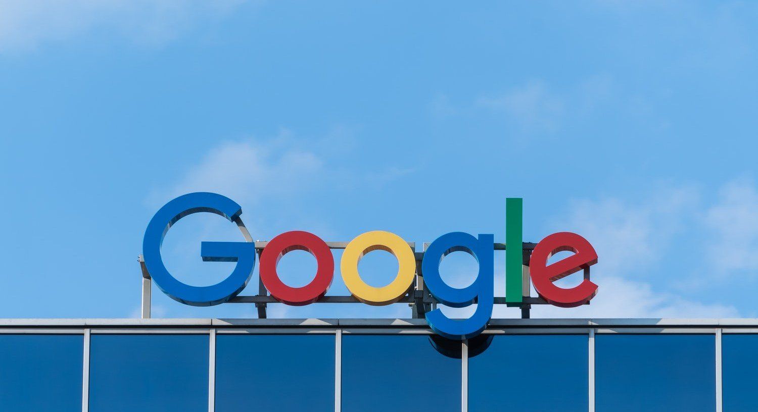 Google logo on a building rooftop against a blue sky