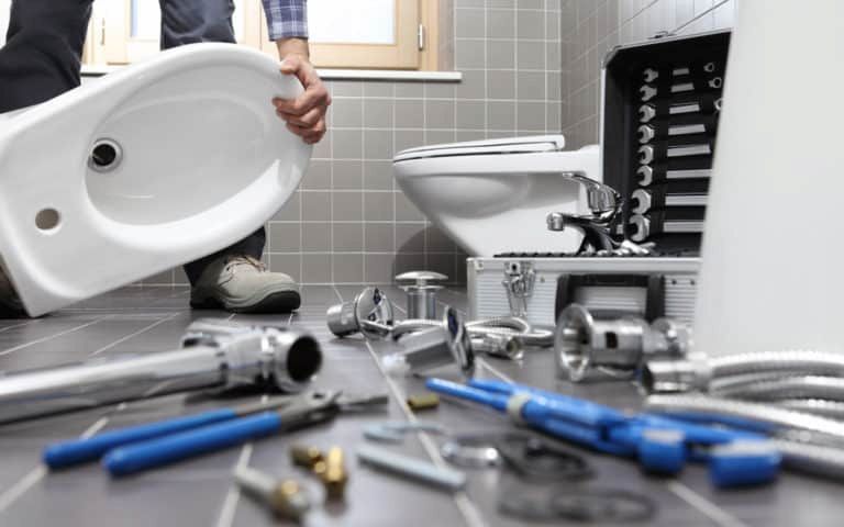 A Plumber Is Installing A Toilet In A Bathroom β ARK Plumbing & Gasfitting In Moss Vale, NSW