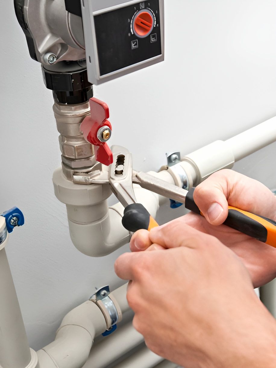 A Person Is Fixing A Pipe With A Wrench And Pliers — ARK Plumbing & Gasfitting In Bowral, NSW