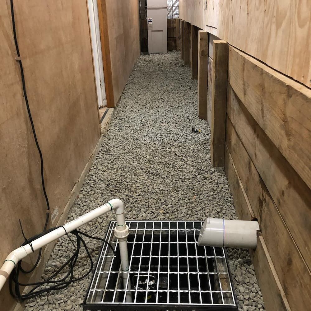 A Drain In A Hallway Next To A Wooden Wall — ARK Plumbing & Gasfitting In Bowral, NSW