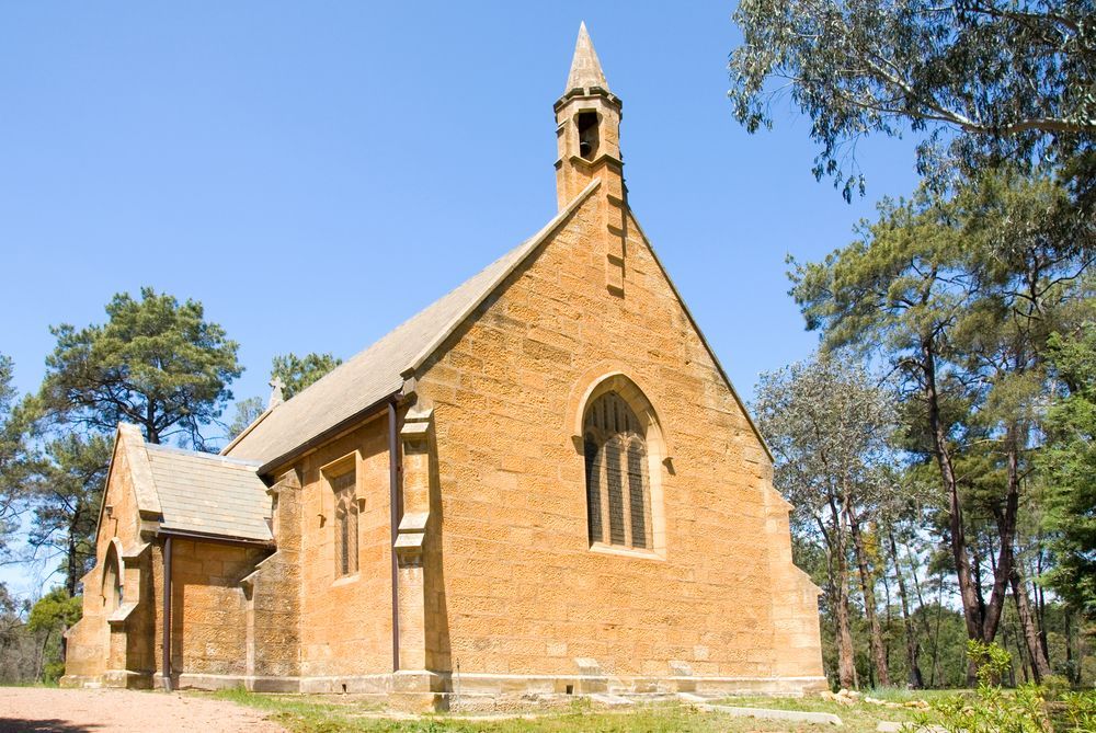 A Small Brick Church With A Steeple In The Middle Of A Forest — ARK Plumbing & Gasfitting In Berrima, NSW