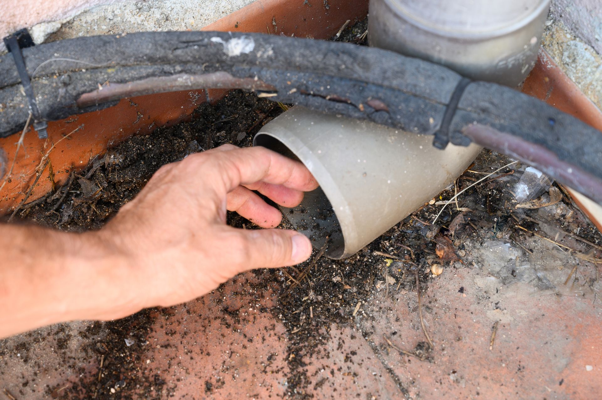 A person is holding a piece of pipe in their hand.