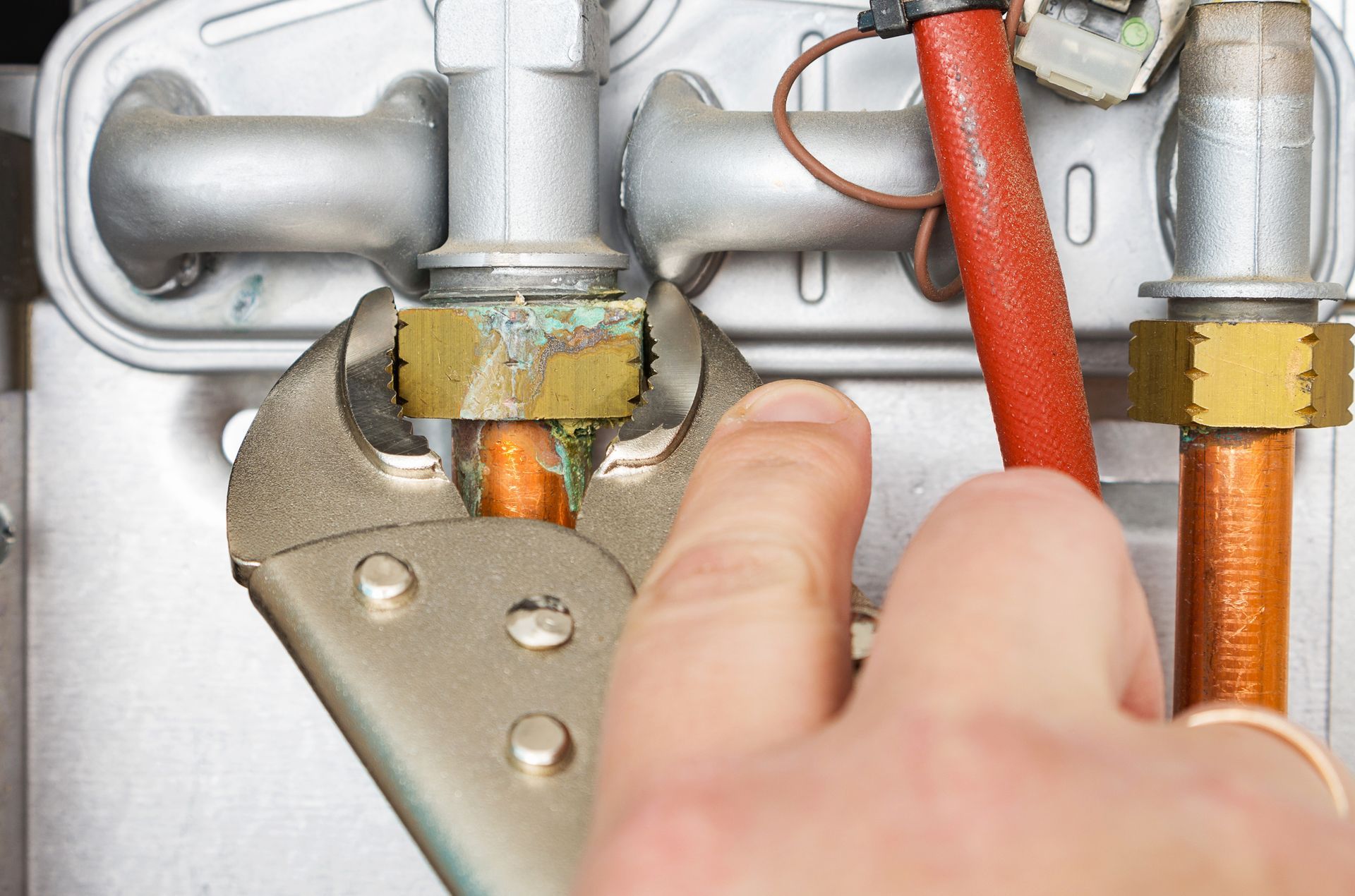 A person is fixing a pipe with a wrench.