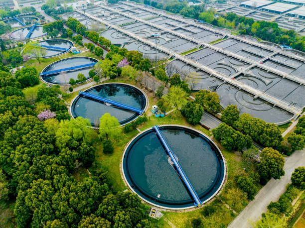 An aerial view of a water treatment plant surrounded by trees.