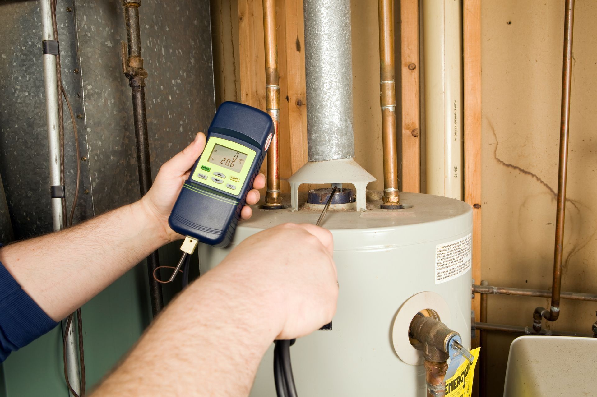 A person is measuring the temperature of a water heater