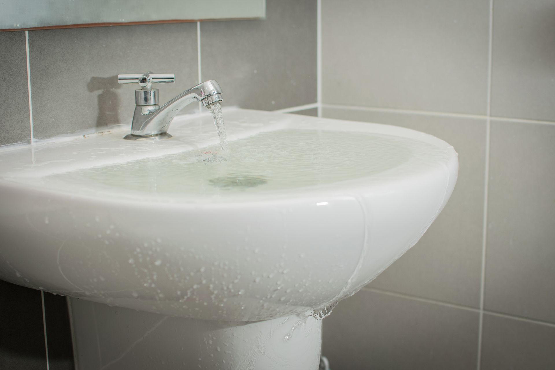 A bathroom sink with water running out of the faucet.