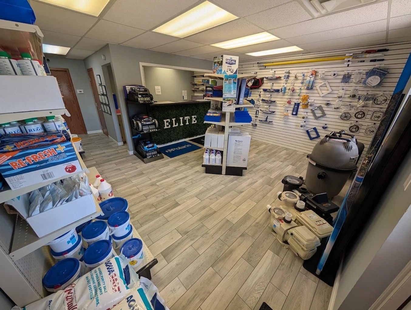 Bright retail store interior with pet supplies, shelves, display racks, and a grill by the entrance