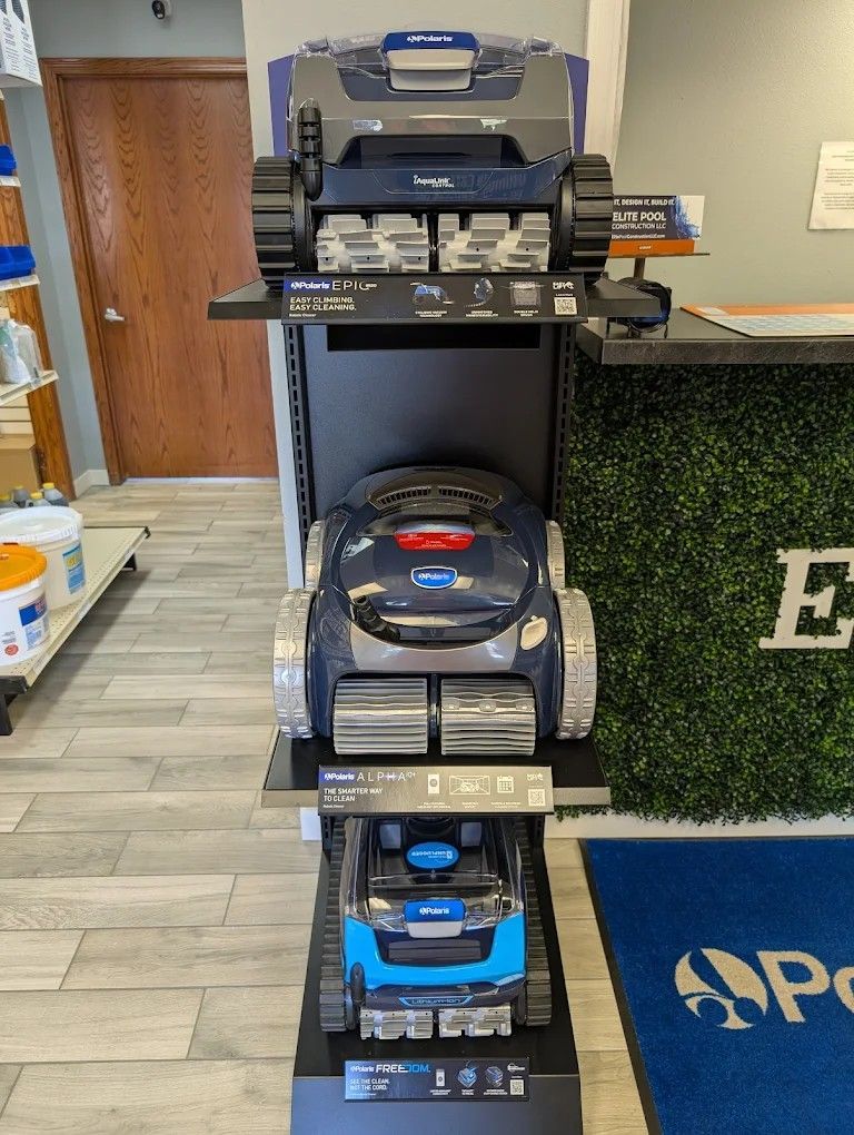 Display of small boomboxes and a CD player on a store shelf beside a green artificial hedge wall