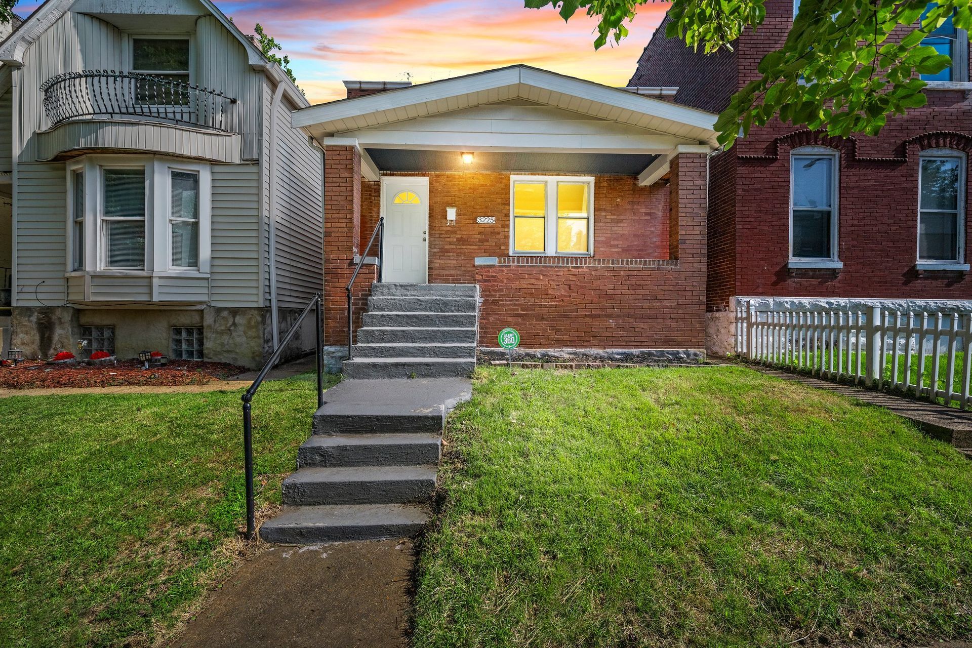 A brick house with stairs leading up to the front door.