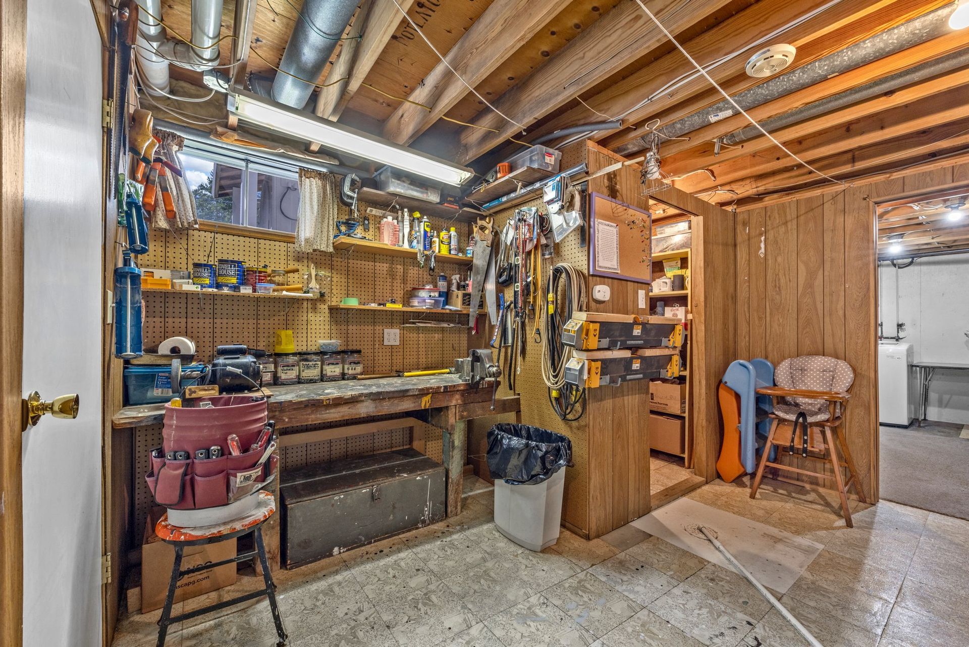 A basement with a workbench and lots of tools.