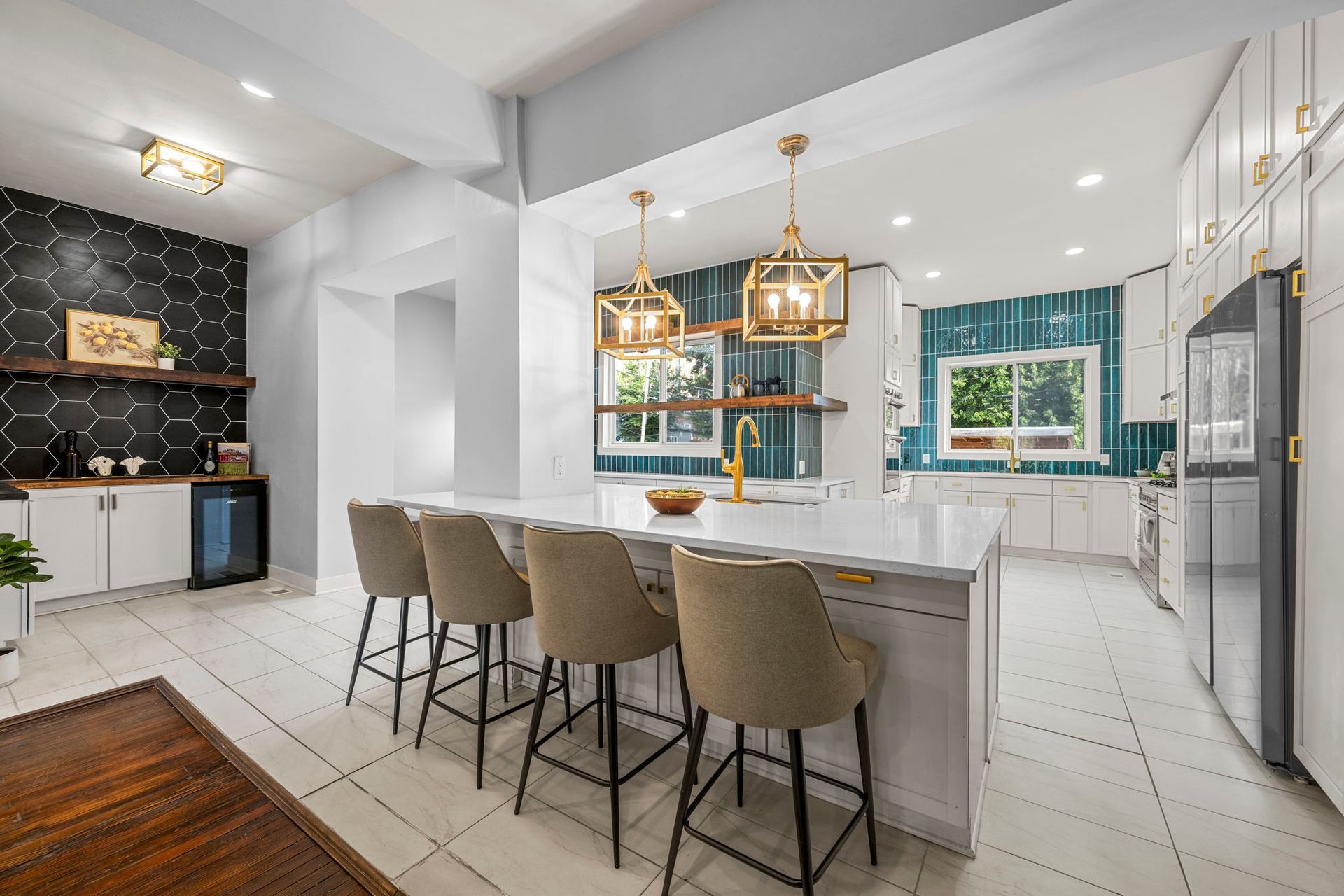 Modern kitchen with white cabinetry, large island, and teal tile accents.