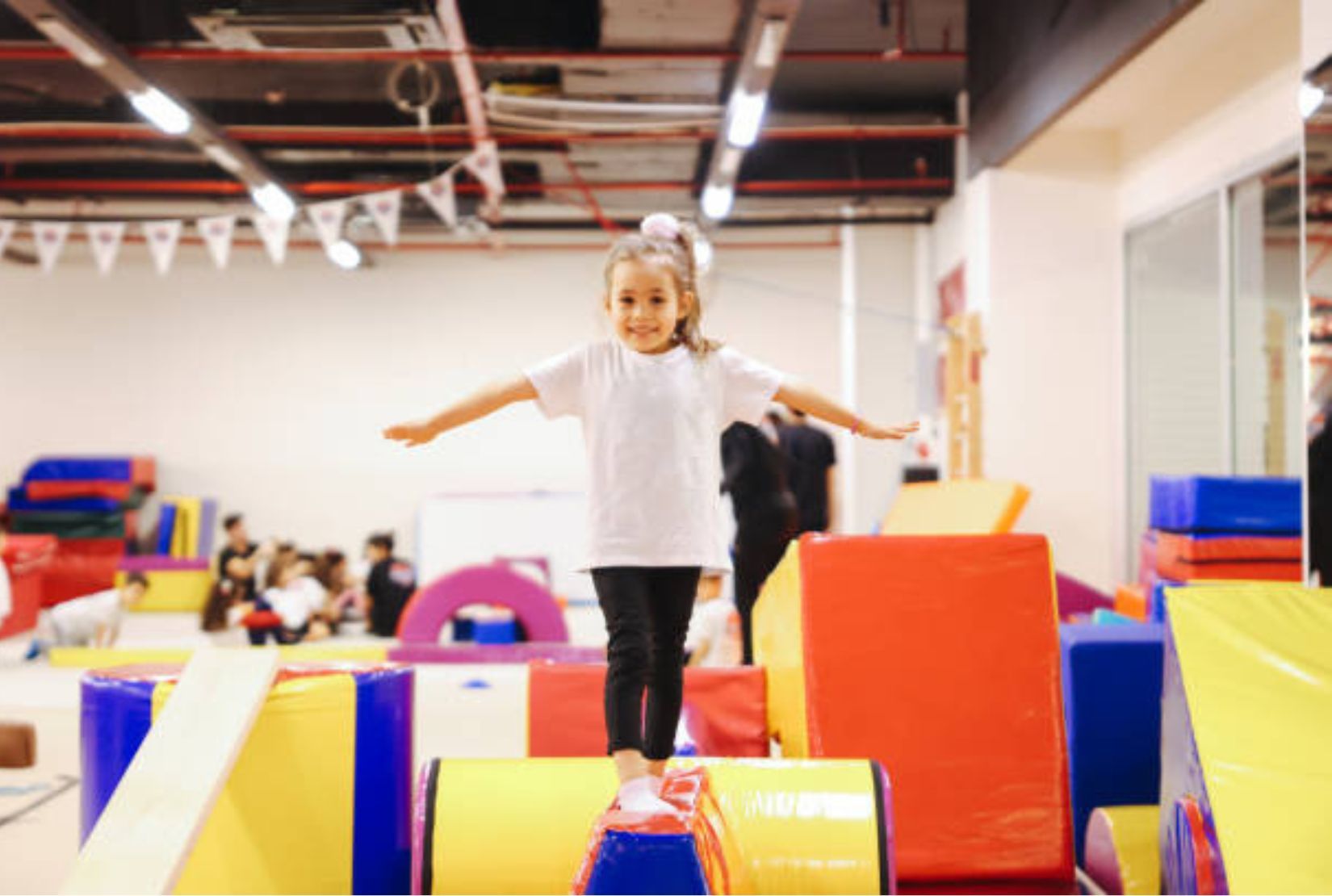 A group of young children are sitting in a play tunnel.
