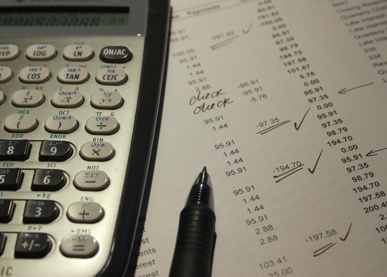 A calculator sits on top of a piece of paper that says check check